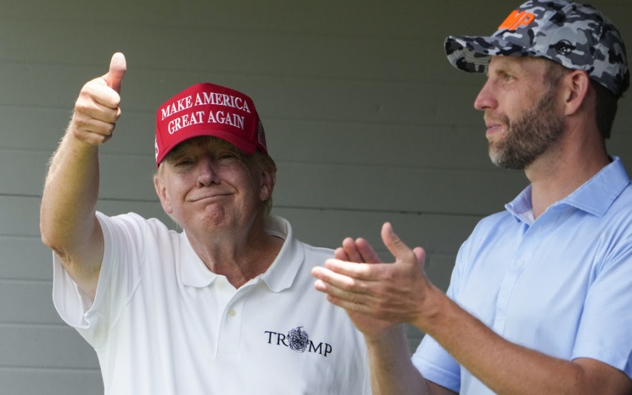 El expresidente Donald Trump saluda a los fanáticos entre la multitud mientras está de pie con su hijo Eric Trump para ver la segunda ronda del LIV Golf en el Trump National Golf Club, el sábado 27 de mayo de 2023, en Sterling, Virginia. Alex Brandon/AP