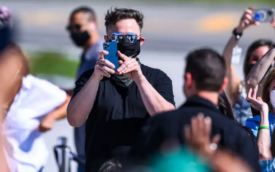 Elon Musk toma una foto en su teléfono durante un lanzamiento de SpaceX